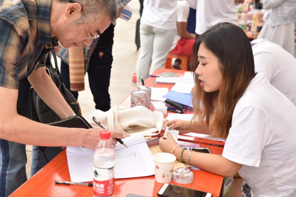 新生报到现场，工作人员正在为家长答疑